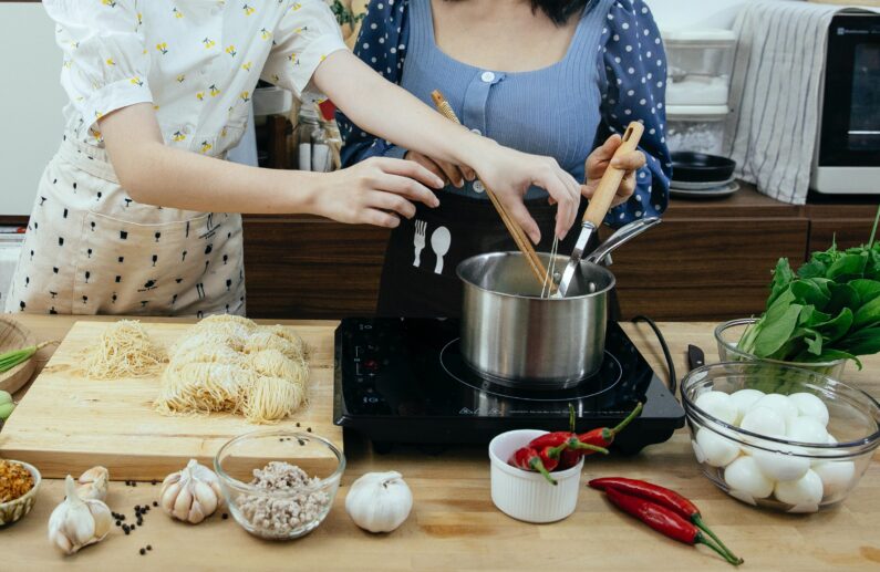 Kobiety w kuchni gotuja w garnkach nierdzewnych